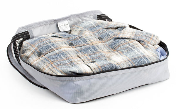 A few button-down shirts folded in an open Northwest Sky (light grey) Aether Aeronaut 30 Large Packing Cube.